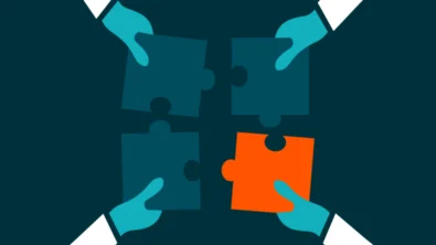 3 licht blauwe puzzelstukken en 1 oranje puzzelstuk vast gehouden door 4 handen