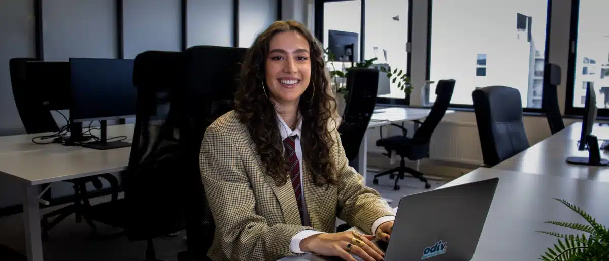 Getinte vrouw glimlachend aan het werken met laptop