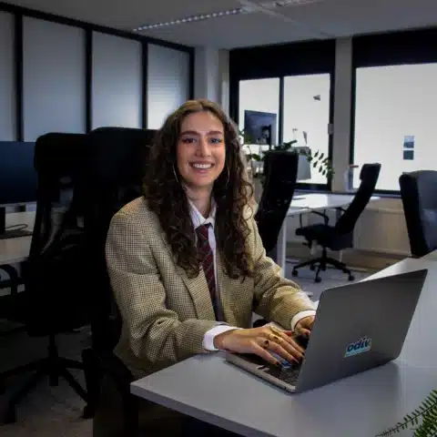 Getinte vrouw glimlachend aan het werken met laptop