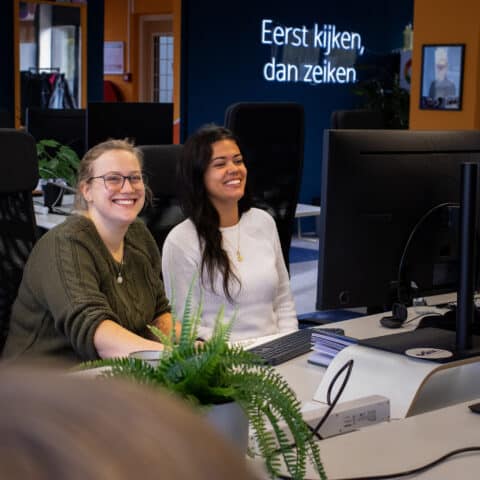 Witte en getinte vrouw lachend aan het werk