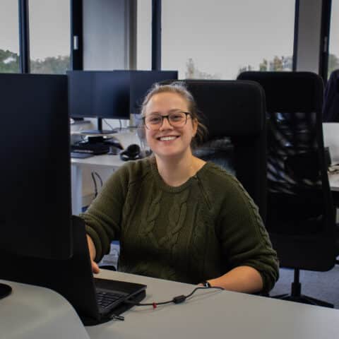 Witte vrouw lachend achter laptop