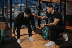 Personal trainer begeleidt een sporter tijdens een deadlift