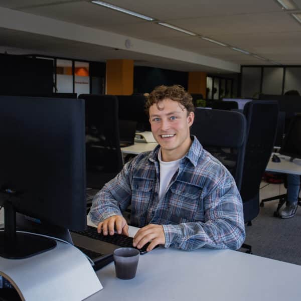 Witte man lachend achter computer