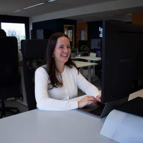 Witte vrouw lachend achter laptop