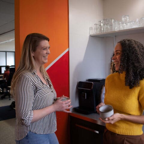Collega’s die een praatje maken en koffie drinken.