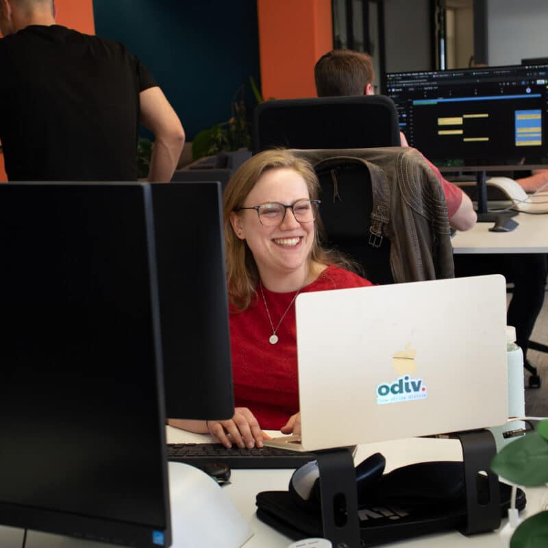 Een collega die aan het werk is en glimlacht.