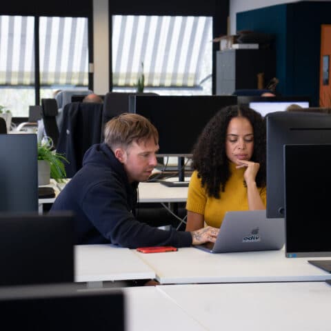 Een man en een vrouw die samen achter de computer zitten te werken