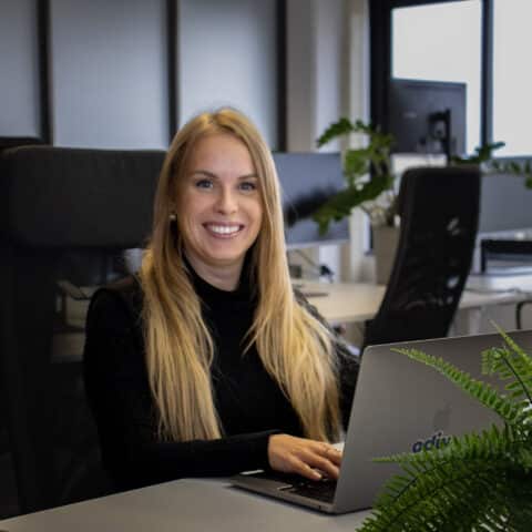 Witte vrouw lachend achter laptop aan het werk