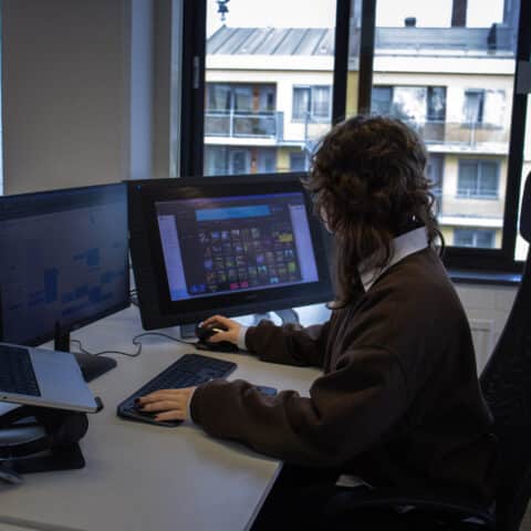 Witte vrouw werkend achter computerscherm