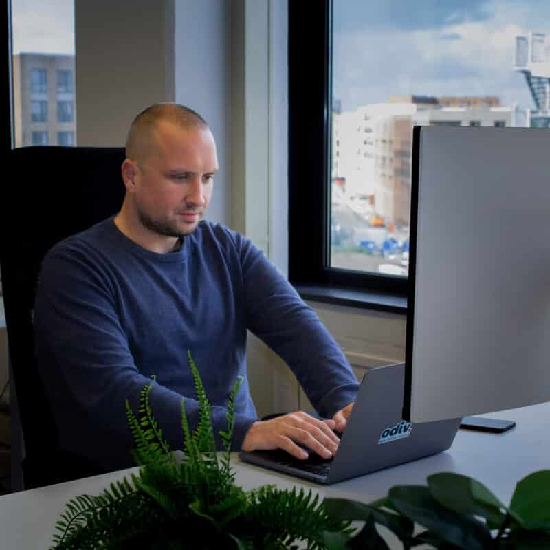 Witte man werkend achter laptop